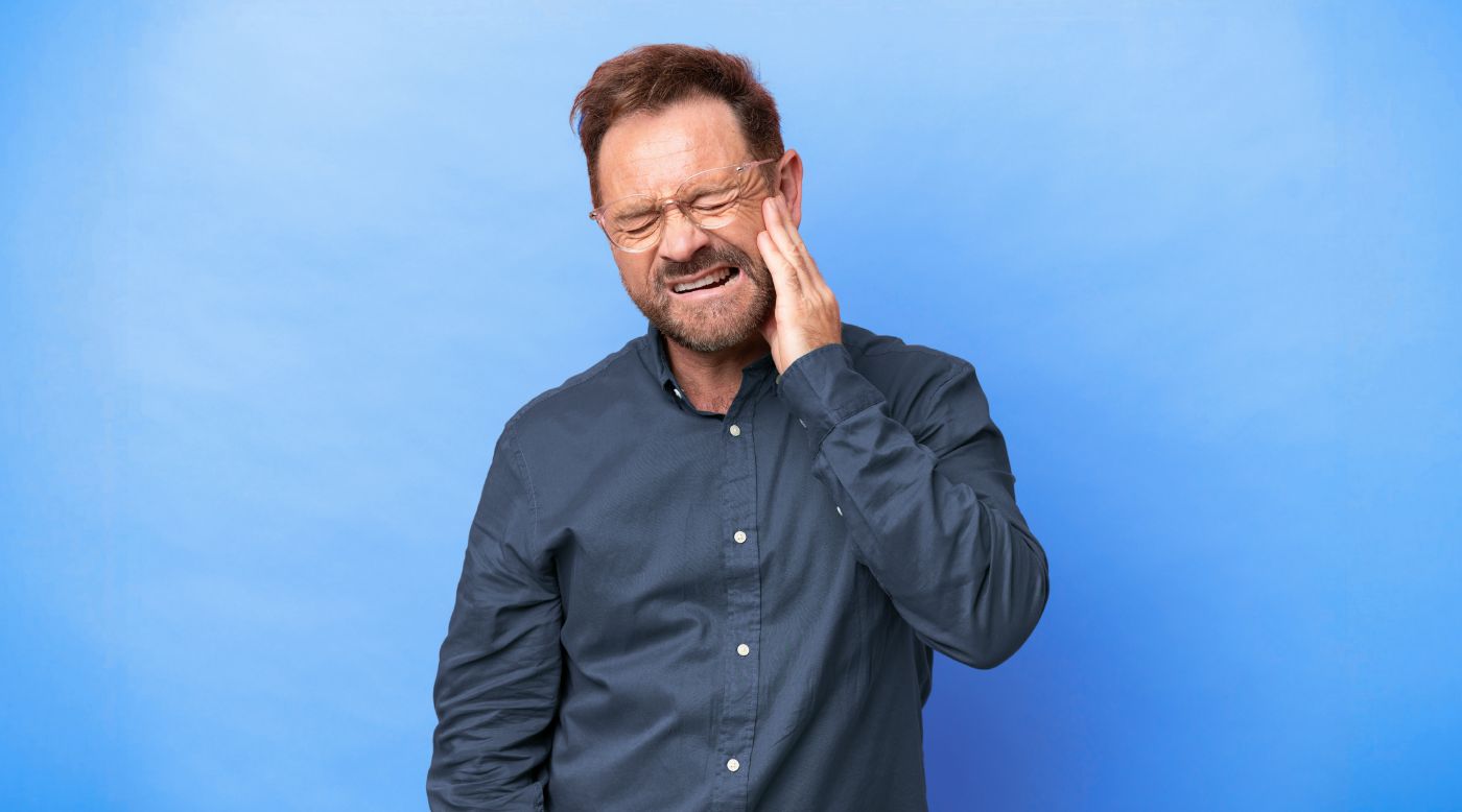 Mann reibt sich morgens den Kiefer im Badezimmer 